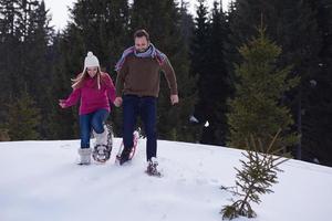 paar, das spaß hat und in schneeschuhen geht foto