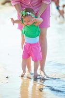 Mama und Baby am Strand haben Spaß foto