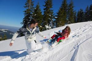 familie, die spaß auf frischem schnee im winter hat foto
