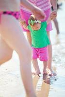 Mama und Baby am Strand haben Spaß foto