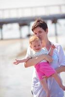 Mama und Baby am Strand haben Spaß foto