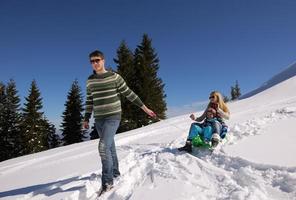 familie, die spaß auf frischem schnee im winterurlaub hat foto