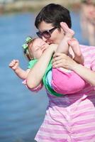 Mama und Baby am Strand haben Spaß foto