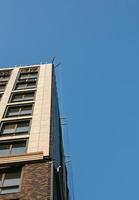 Baukran gegen den blauen Himmel. die Immobilienbranche. Ein Kran verwendet Hebezeuge auf einer Baustelle. foto