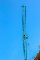 Baukran gegen den blauen Himmel. die Immobilienbranche. Ein Kran verwendet Hebezeuge auf einer Baustelle. foto