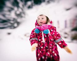 kleines Mädchen am Tag des verschneiten Winters foto