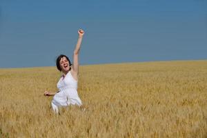 junge Frau im Weizenfeld im Sommer foto