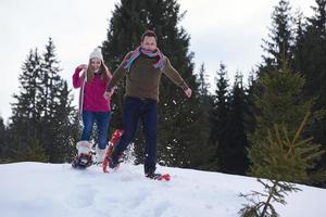 paar, das spaß hat und in schneeschuhen geht foto