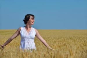 junge Frau im Weizenfeld im Sommer foto