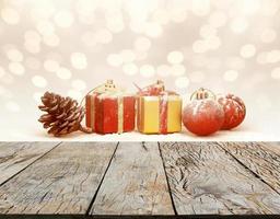 weihnachtsfeiertagshintergrund mit kasten- und kugeldekorationen auf holztisch. rote, goldene und silberne Ornamente foto