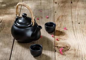 tasse heißen tee mit dampfenden krügen auf dem holztischhintergrund mit kopierraum für ihren text, chinesischer stil foto