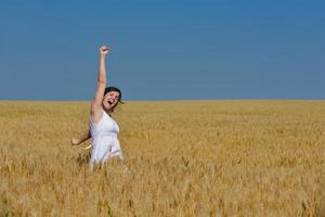 junge Frau im Weizenfeld im Sommer foto