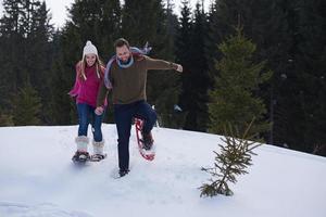 paar, das spaß hat und in schneeschuhen geht foto