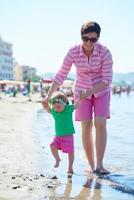 Mama und Baby am Strand haben Spaß foto