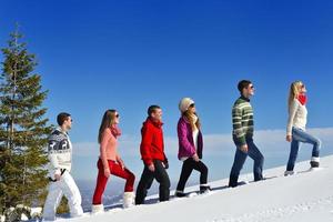 freunde haben spaß im winter auf frischem schnee foto