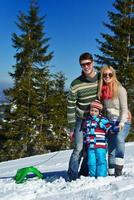 familie, die spaß auf frischem schnee im winter hat foto