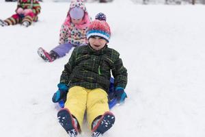 gruppe von kindern, die spaß haben und zusammen im frischen schnee spielen foto