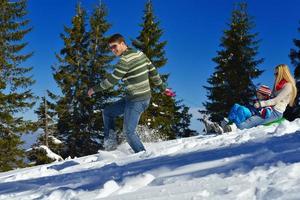 familie, die spaß auf frischem schnee im winterurlaub hat foto