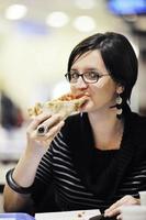 Frau isst Pizza im Restaurant foto