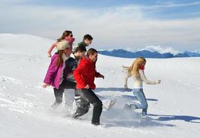 freunde haben spaß im winter auf frischem schnee foto