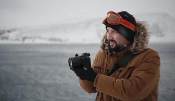 Fotograf im Winter bei stürmischem Wetter mit warmer Pelzjacke foto