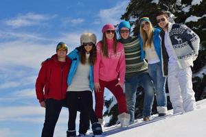 freunde haben spaß im winter auf frischem schnee foto