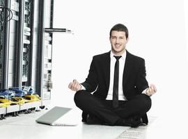 Geschäftsmann praktiziert Yoga im Netzwerkserverraum foto