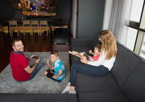 glückliche familie, die ein videospiel spielt foto