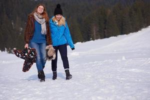 Freundinnen an schönen Wintertagen haben einen entspannten Spaziergang auf Schnee foto