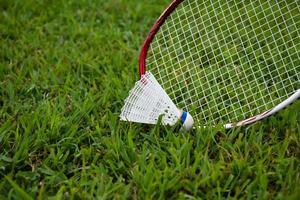 Federbälle und Badmintonschläger für Badminton-Ausrüstungen im Freien, auf Grasrasen, weicher und selektiver Fokus auf Federbälle, Badminton-Spielkonzept im Freien foto