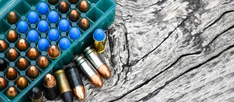 9-mm-Pistolenkugeln und Kugelschalen auf Holztisch, weicher und selektiver Fokus. foto