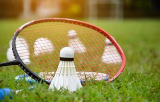 Federbälle und Badmintonschläger für Badminton-Ausrüstungen im Freien, auf Grasrasen, weicher und selektiver Fokus auf Federbälle, Badminton-Spielkonzept im Freien foto