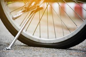 Nahaufnahme hinteres flaches Rad des Oldtimer-Fahrrads auf dem Bürgersteig am Abend des Tages, Sonnenuntergangslicht bearbeitet, weicher und selektiver Fokus foto