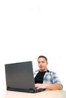junger Mann, der am Laptop arbeitet foto
