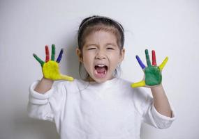 kindliche kreativität, kleine asiatische mädchenhände in bunten farben auf weißem hintergrund gemalt, pädagogisches konzept für die schule foto