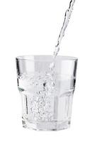 Gießen von frischem, reinem Wasser in ein Glas isoliert auf weißem Hintergrund, Gesundheits- und Schönheitshydratationskonzept foto
