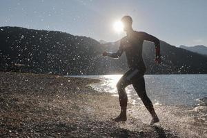 Triathlonsportler beginnt mit dem Schwimmtraining auf dem See foto