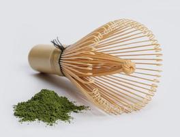 japanischer Schneebesen mit Haufen Matcha-Grüntee-Pulver isoliert auf weißem Hintergrund, Bio-Produkt aus der Natur für gesundes mit traditionellem Stil foto