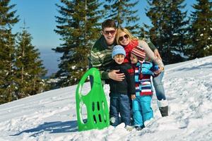 familie, die spaß auf frischem schnee im winter hat foto