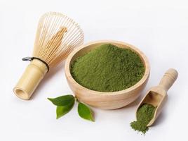 Matcha-Grüntee-Pulver in Schüssel mit Bio-Grünteeblatt und japanischem Schneebesen isoliert auf weißem Hintergrund, Bio-Produkt aus der Natur für gesundes mit traditionellem Stil foto