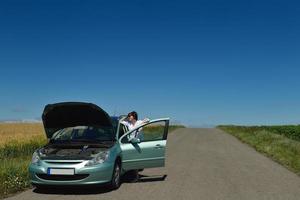 Frau mit kaputtem Auto foto