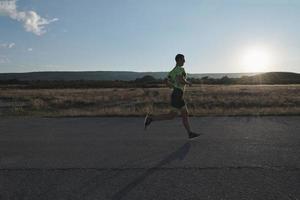 triathlonsportler, der beim morgendlichen training läuft foto