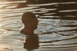 triathlet-schwimmer, der während des harten trainings eine pause macht foto