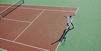 junger mann spielt tennis foto