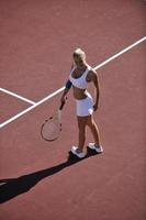 junge Frau spielt Tennis im Freien foto