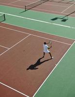 junger mann spielt tennis foto