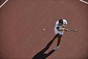 junger mann spielt tennis foto