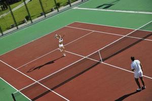 glückliches junges paar spielt tennisspiel im freien foto