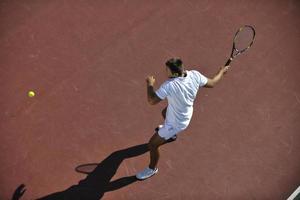 junger mann spielt tennis foto