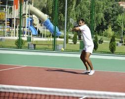 junger Mann spielt Tennis im Freien foto